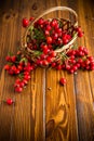 Ripe red dogrose in a basket on a wooden