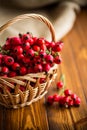Ripe red dogrose in a basket on a wooden