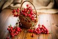 Ripe red dogrose in a basket on a wooden