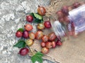 Ripe red gooseberries and leaves fall out of the glass jar on the burlap. Top view Royalty Free Stock Photo