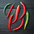 Ripe Red and green chili pepper, on black wooden table background, top view flat lay Royalty Free Stock Photo