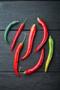 Ripe Red and green chili pepper, on black wooden table background, top view flat lay Royalty Free Stock Photo