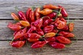 Ripe red Habanero peppers on rustic wooden table in bright sunlight