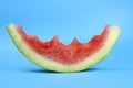 ripe red juicy watermelon slice bitten off on a blue background Royalty Free Stock Photo