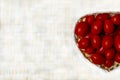 Ripe red mini cherry tomatoes lies in a basket and on a light gray background with copy space Royalty Free Stock Photo