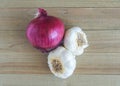 A red onion and 2 garlic bulbs on a wood background Royalty Free Stock Photo