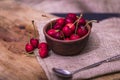 Ripe red organic cherries in a bowl and next to it on wooden table Royalty Free Stock Photo