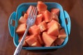 Ripe red papaya fruit that has been cut, with a fork in a purple box, on the table Royalty Free Stock Photo