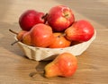 Ripe red pears and apple in the rod basket on the wooden table Royalty Free Stock Photo