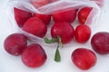 Ripe red plums rolling out of a plastic bag Royalty Free Stock Photo