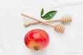 Ripe red pomegranate wooden honey dippers spoons green leaves on pure cotton white cloth. Natural organic cosmetics ingredients