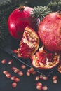 Ripe  red   pomegranates , pomegranate seeds fir branches on a dark background Royalty Free Stock Photo