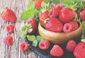 Ripe red raspberries and strawberries in wooden bowl, selective focus Royalty Free Stock Photo