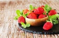 Ripe red raspberries and strawberries in wooden bowl, selective focus Royalty Free Stock Photo