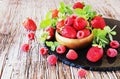 Ripe red raspberries and strawberries in wooden bowl, selective focus Royalty Free Stock Photo