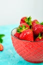 Ripe red strawberries on blue table, Strawberries in red bowl. Fresh strawberries. Royalty Free Stock Photo