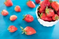 Ripe red strawberries on blue wooden table, Fresh strawberry, Strawberries in white bowl. Royalty Free Stock Photo