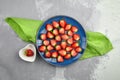 Ripe red strawberries on ceramic plates flat lay on grey concrete table background Royalty Free Stock Photo