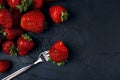 Ripe red strawberries with fork on a dark blue background. Space for text Royalty Free Stock Photo