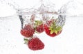 Ripe red strawberries are thrown and dropped into sparkling water, many bubbles Royalty Free Stock Photo