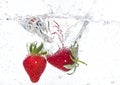 Ripe red strawberries are thrown and dropped into sparkling water, many bubbles Royalty Free Stock Photo