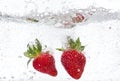 Ripe red strawberries are thrown and dropped into sparkling water, many bubbles Royalty Free Stock Photo