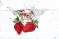 Ripe red strawberries are thrown and dropped into sparkling water, many bubbles Royalty Free Stock Photo
