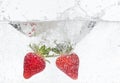 Ripe red strawberries are thrown and dropped into sparkling water, many bubbles Royalty Free Stock Photo