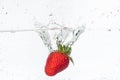 Ripe red strawberries are thrown and dropped into sparkling water, many bubbles Royalty Free Stock Photo