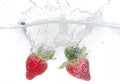 Ripe red strawberries are thrown and dropped into sparkling water, many bubbles Royalty Free Stock Photo