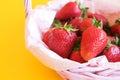 Ripe red strawberries in wicker basket on yellow background. Summer harvest. Fresh strawberries. Royalty Free Stock Photo