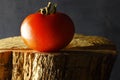 RIPE RED TOMATO ON A WOODEN SURFACE WITH GREY BACKGROUND Royalty Free Stock Photo