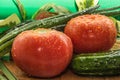 Ripe red tomatoes, green cucumbers, green onion feathers are covered with large drops of water Royalty Free Stock Photo