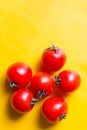 Ripe red tomatoes with green leaves isolated on yellow background. Top view Royalty Free Stock Photo