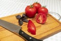 Ripe red tomatoes with a sprig of basil and knife