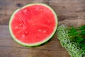 Ripe red watermelon, cut in half, home cooking concept, white wildflowers, wooden table, texture of natural background, delicious