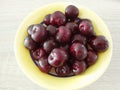 Ripe red wet cherries in yellow bowl, from above, close up Royalty Free Stock Photo