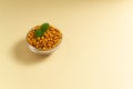 Ripe sea buckthorn berries in a glass bowl and a sprig of mint on a yellow background. Royalty Free Stock Photo