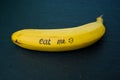 Ripe single banana on a table with writing