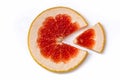 Ripe slice of red grapefruit on a white background close-up. Citrus isolated object. Cut a slice of sour fruit