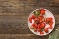 Ripe and spoiled strawberries on a white dish, top view