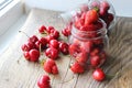 Ripe strawberries and cherries , glass jars. Wood background, rustic style. Royalty Free Stock Photo