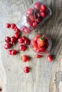 Ripe strawberries and cherries , glass jars. Wood background, rustic style. Royalty Free Stock Photo