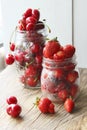 Ripe strawberries and cherries , glass jars. Wood background, rustic style. Royalty Free Stock Photo