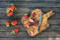 Ripe strawberries on a cutting board on wooden background. Fresh farmerÃ¢â¬â¢s organic strawberries in tiny metal vintage basket on Royalty Free Stock Photo