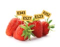 Ripe strawberries with E numbers on background. Harmful food additives Royalty Free Stock Photo