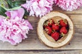 Ripe strawberries in a heart carved into the wood with pink peon Royalty Free Stock Photo