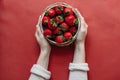 Top view of strawberries in bowl on red background bouquet of peonies Royalty Free Stock Photo