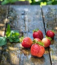 Strawberries lie on a wooden table outdoors