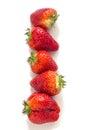 Ripe strawberries lined in a row on a white background